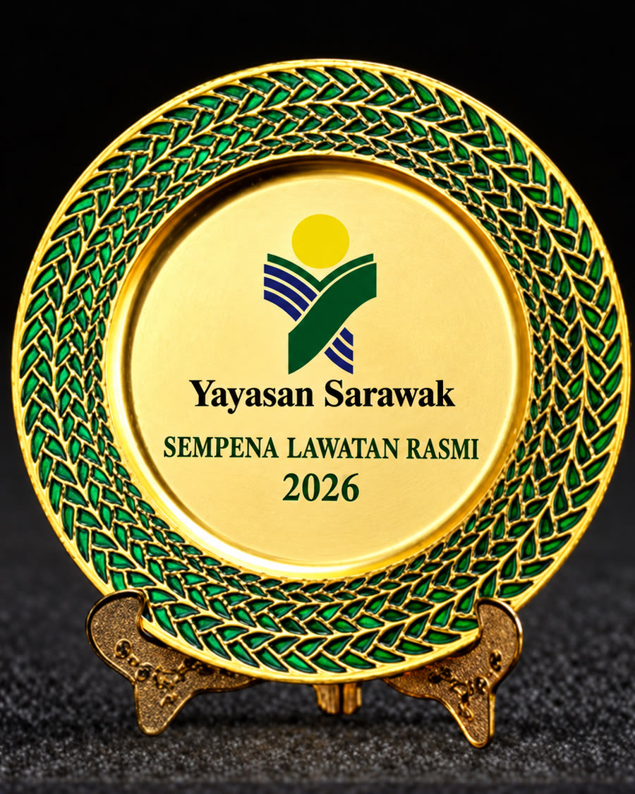Gold commemorative plate with a green enamel rim and the Yayasan Sarawak logo, on a stand