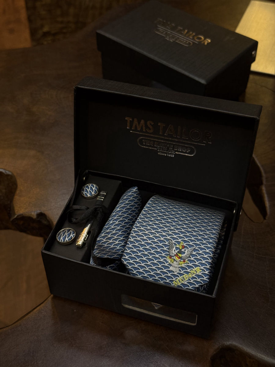 MUDeNR Signature Set in an open TMS Tailor box: tie, pocket square, fabric-covered cufflinks and tie clip