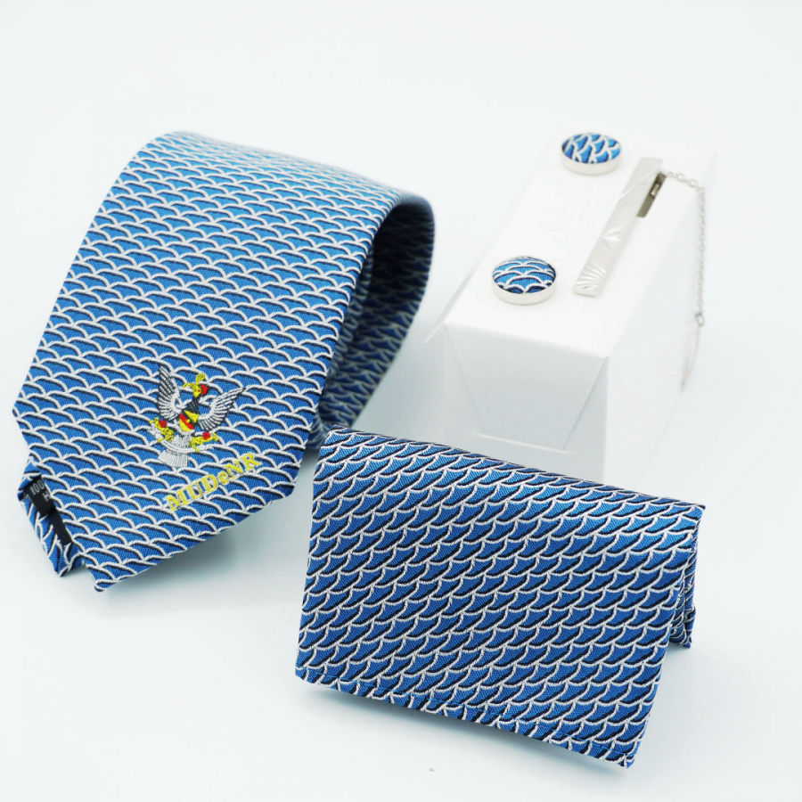 Matching tie, pocket square and fabric-covered cufflinks in a blue wave pattern